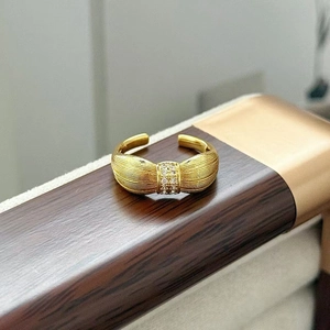 Dettaglio dell'anello vintage a fiore con finitura in oro spazzolato e zirconi lucenti