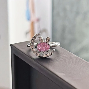 Dettaglio macro dell'anello a luna d'argento con pietra rosa e orecchie di coniglio