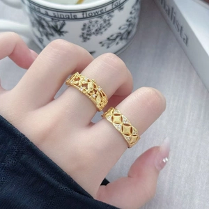 Dettaglio di anelli vintage a fiori e geometrici in oro con zirconi sulla mano