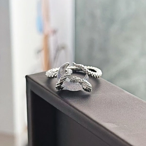 Dettaglio dell'anello aperto con luna e serpente argento e texture di squame