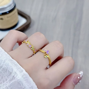 Detail von Vintage-Emaille-Ringen mit lila Herz- und grünen Blattmustern in Goldoptik