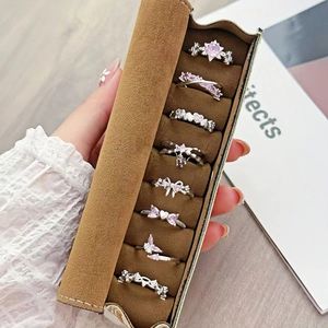 Pink zircon heart and bow adjustable rings with brown suede jewelry storage roll organizer