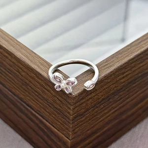 Macro detail of silver adjustable ring with pink zircon butterfly and white bead