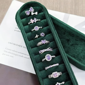 Luxury 10-piece silver ring set with purple zircon gemstones in a green velvet box