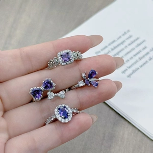 Exquisite silver ring set with purple gemstones in heart and pear shapes on finger