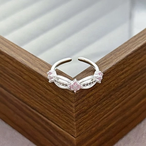 Detailed macro of silver adjustable ring featuring pink zircon stones and pavé crystals