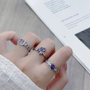 Three elegant purple zircon silver open rings displayed on a hand in a stylish setting
