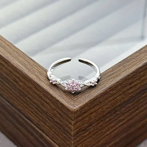 Detail of silver adjustable ring with pink zircon flower and twisted band design