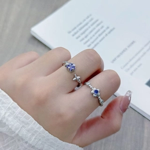 Macro view of stackable silver rings with purple star and blue flower zircon gems