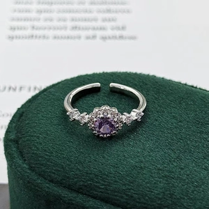 Macro shot of a purple halo ring with silver band and white zircon accents on velvet