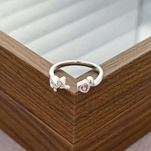 Macro shot of silver adjustable cat ring featuring a sparkling pink heart cubic zirconia