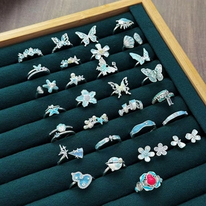 Emaille Blumen- und Flaschenkürbis-Ringe in Blau und Weiß auf einem Samttablett