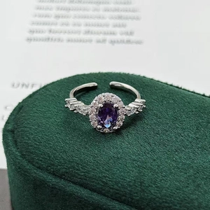 Detailed macro view of the oval purple gemstone and cubic zirconia on silver ring