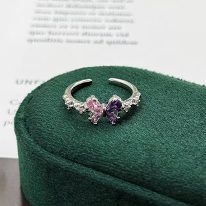 Detailed macro view of silver butterfly ring with pink and purple pear-shaped gemstones