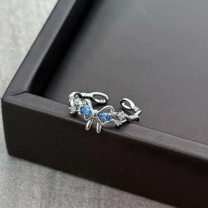 Detail of silver bow ring with blue zircon stones and twisted band design