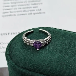 Macro view of purple heart-shaped gemstone ring with silver plating on velvet box
