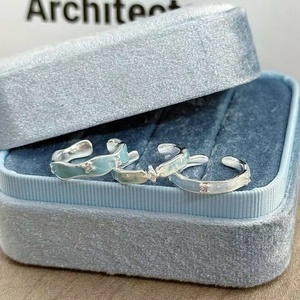 Makroansicht hellblauer Emaille-Ringe mit Zirkonia-Inlay in einer Samtbox
