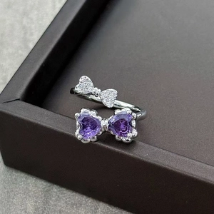 Detailed close-up of double bow ring with purple heart stones and sparkling pavé crystals