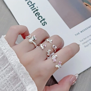 Detail of adjustable silver rings with pink zircon, featuring cat and bear designs