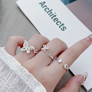 Detailed view of silver rings featuring pink zircon butterfly and cat claw designs
