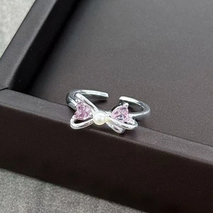 Detail of silver bow ring with pink heart zirconia and central white pearl accent