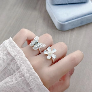 Detailansicht der Emaille Schmetterling und Blumenringe mit Perlen auf blauer Box