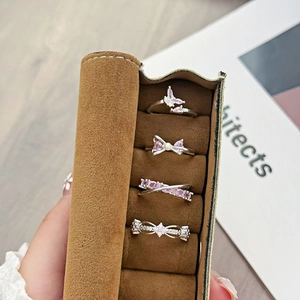 Detailed close-up of a silver ring set featuring pink zircon stones in a velvet case