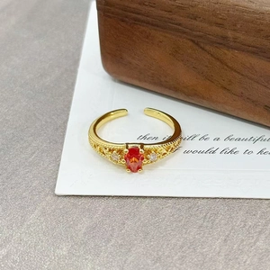 Detail of vintage gold open ring with orange pear-cut zircon and floral engraving