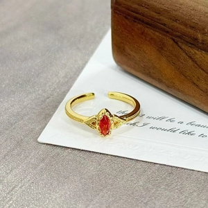 Detailed close-up of retro gold open ring with marquise red zircon and floral engravings