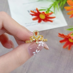Detailed close-up of a vintage golden crown ring with orange zircon and floral open design