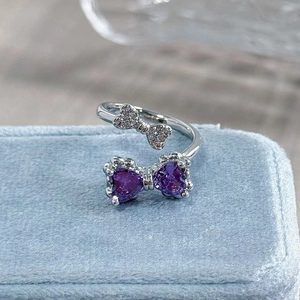 Macro detail of butterfly ring with purple heart stones and white cubic zirconia crystals