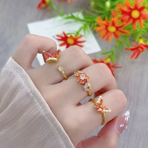 Detailed shot of vintage gold rings with orange zircon flowers and butterfly patterns