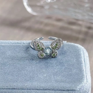 Macro shot of butterfly open ring with blue gemstone and diamonds on blue velvet box