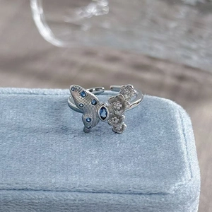 Macro shot of a silver butterfly ring with blue crystals on a velvet jewelry box