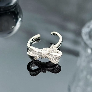 Macro shot of sparkling zircon bow ring with polished silver finish and adjustable band