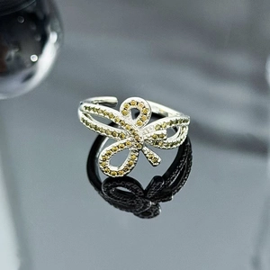 Macro detail of silver bow ring featuring sparkling yellow zircon micro-pave setting
