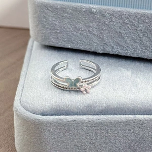 Makroaufnahme Silberring mit Emaille-Schmetterling, Blume und funkelnden Diamanten