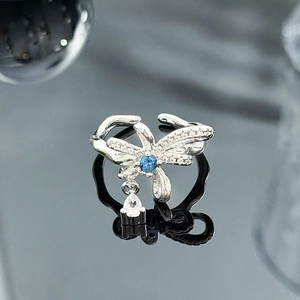 Macro shot of silver dragonfly ring with blue center stone and crystal wings