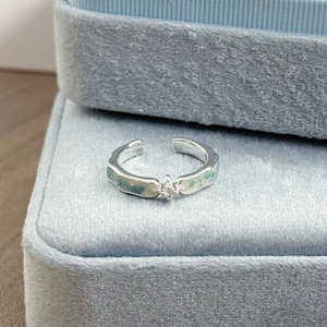 Nahaufnahme des hellblauen Emaille-Blumenrings mit Zirkon-Inlay auf Samtbox
