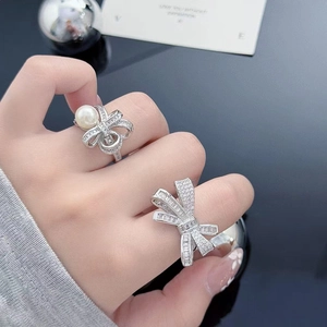 Detail of bow-shaped ring featuring sparkling cubic zirconia and elegant pearl accents