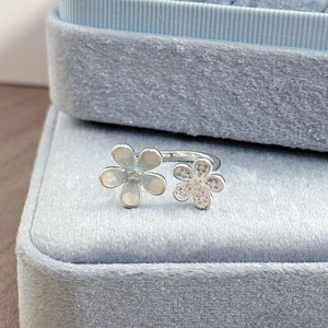 Makroaufnahme von Silberring mit blauer Emaille-Blume und glitzernden Mikrokristallen