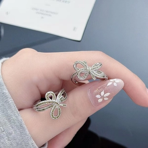 Detailed view of two bow-shaped rings featuring micro-paved sparkling zircon stones