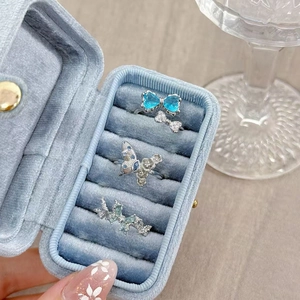 Detailed view of silver open rings with blue heart butterfly and sparkling zircon crystals