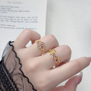 Detail von Vintage-Goldringen mit lila Zirkonia und schwarzen Spitzenmanschetten