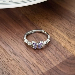 Close-up of butterfly ring with purple zircon wings and woven silver-tone band