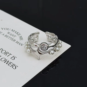 Detail eines silbernen Punk-Rings mit Zirkonia und weißen Perlen, offenes Design