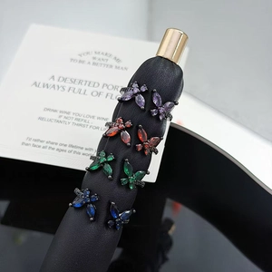 Macro shot of colorful butterfly stud earrings set with zircon stones on a black stand