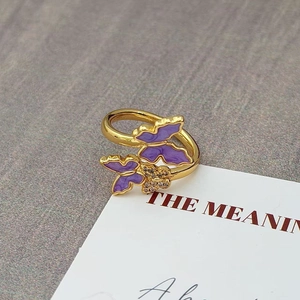Macro-opname van een vintage gouden ring met paarse emaille en kristallen vlinders