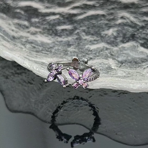 Macro shot of double butterfly ring featuring purple zircon stones on black plated metal