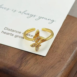 Détail de la bague papillon dorée avec une aile brossée et une aile sertie de zircons